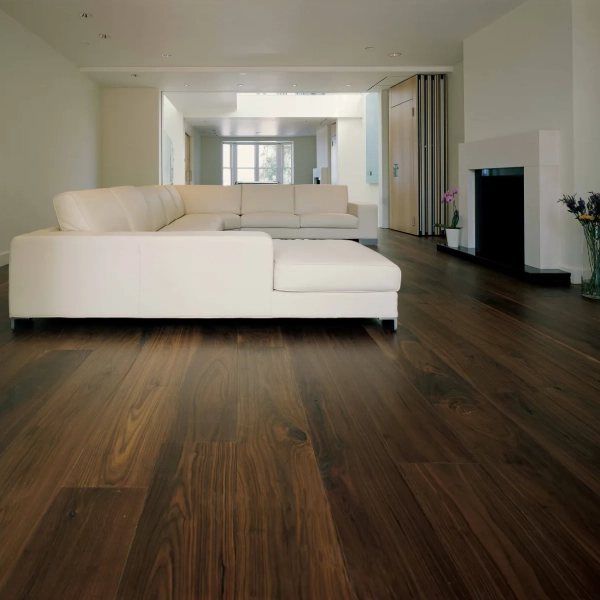 A living room with rich, dark brown, wide-plank wood flooring in Dubai