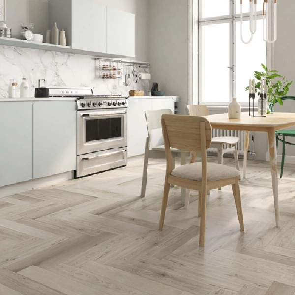 Light-toned wood-look flooring laid in a herringbone pattern in a bright