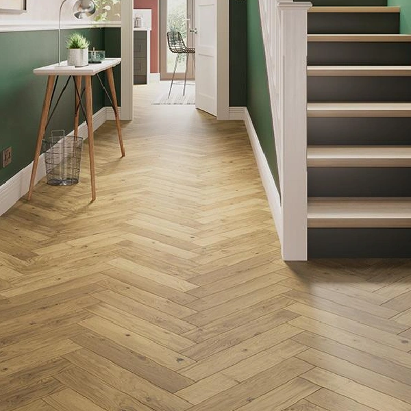 Medium-toned wood-look flooring laid in a herringbone pattern in a hallway