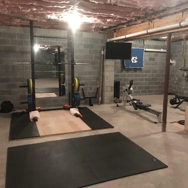Basement home gym with concrete floor and block walls.