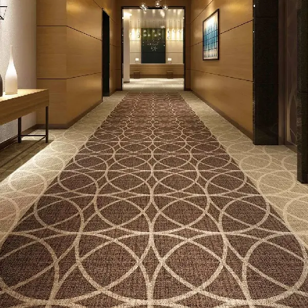 Hotel hallway featuring a wall-to-wall carpet
