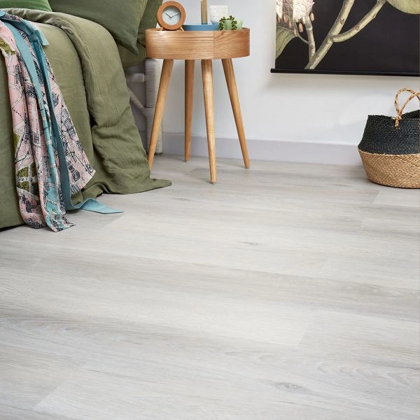 Light grey washed wood-effect vinyl click flooring next to a wooden bedside