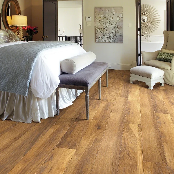 Medium-toned, rustic brown laminate flooring shown in a bright bedroom setting.