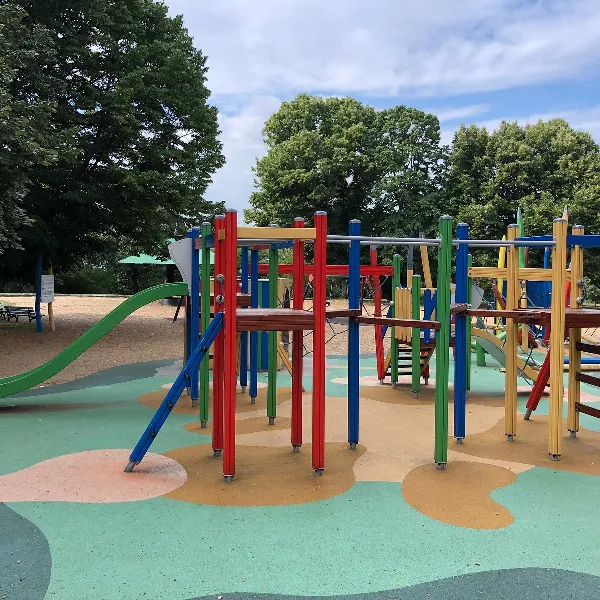 Outdoor playground with a multi-colored play structure and a seamless EPDM floor