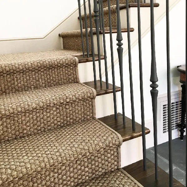 Sisal carpet runner on dark wood stairs and railing.