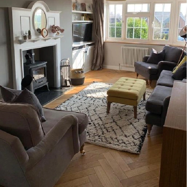 Solid wood flooring laid in a herringbone pattern in a cozy living room.