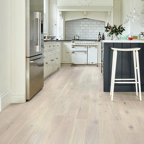 Solid wood flooring with wide, white-washed planks in a kitchen