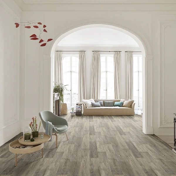 Wide planks of gray-toned distressed wood-look vinyl flooring