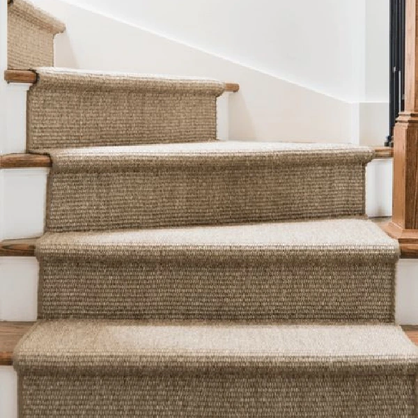 Woven beige sisal carpet runner on a staircase.