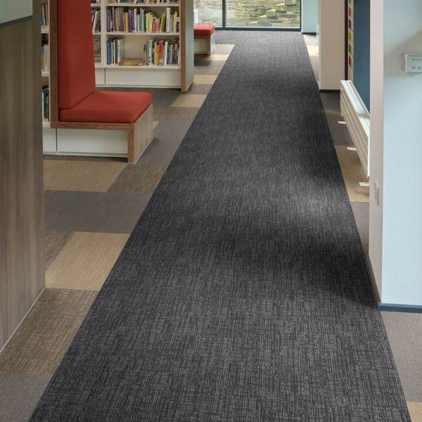 linear-patterned carpet runner leading down an office hallway