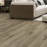 medium brown WPC plank flooring beneath the base of a modern sofa.